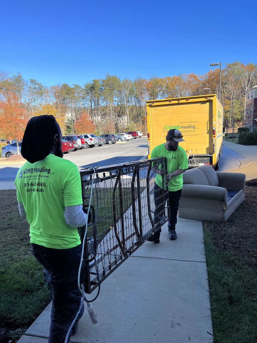SOMD Hauling crew carrying a crib and sofa out for junk removal