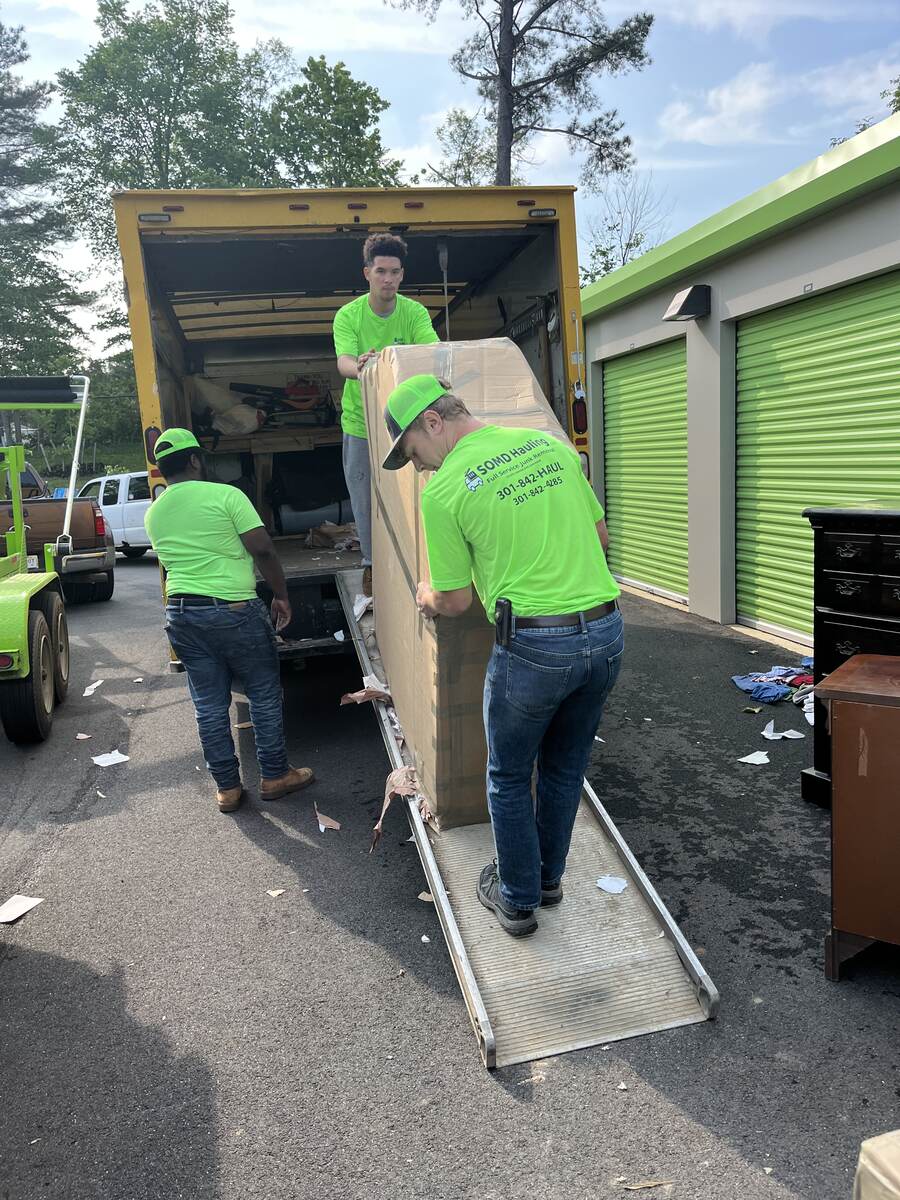 SOMD Hauling crew in branded shirts loading furniture into a truck