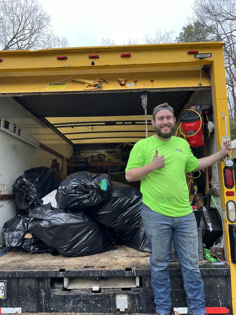 SOMD Hauling crew member giving a thumbs up after clearing out a truck full of junk