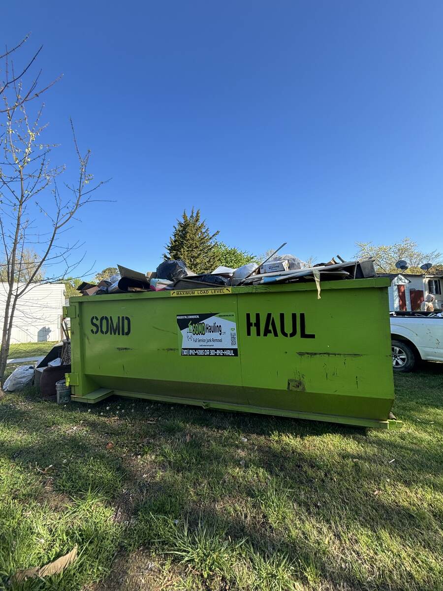 SOMD Hauling roll-off dumpster full of junk after a residential clean-out